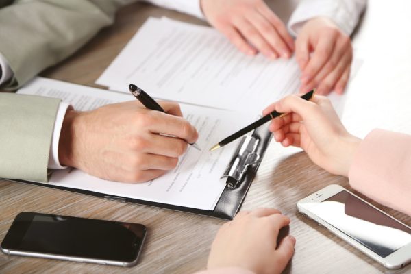 A group of people sitting around a table with papers.